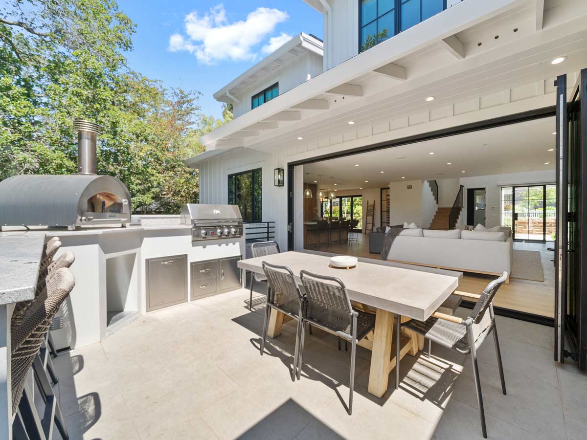 Sunny outdoor patio with table and bbq.