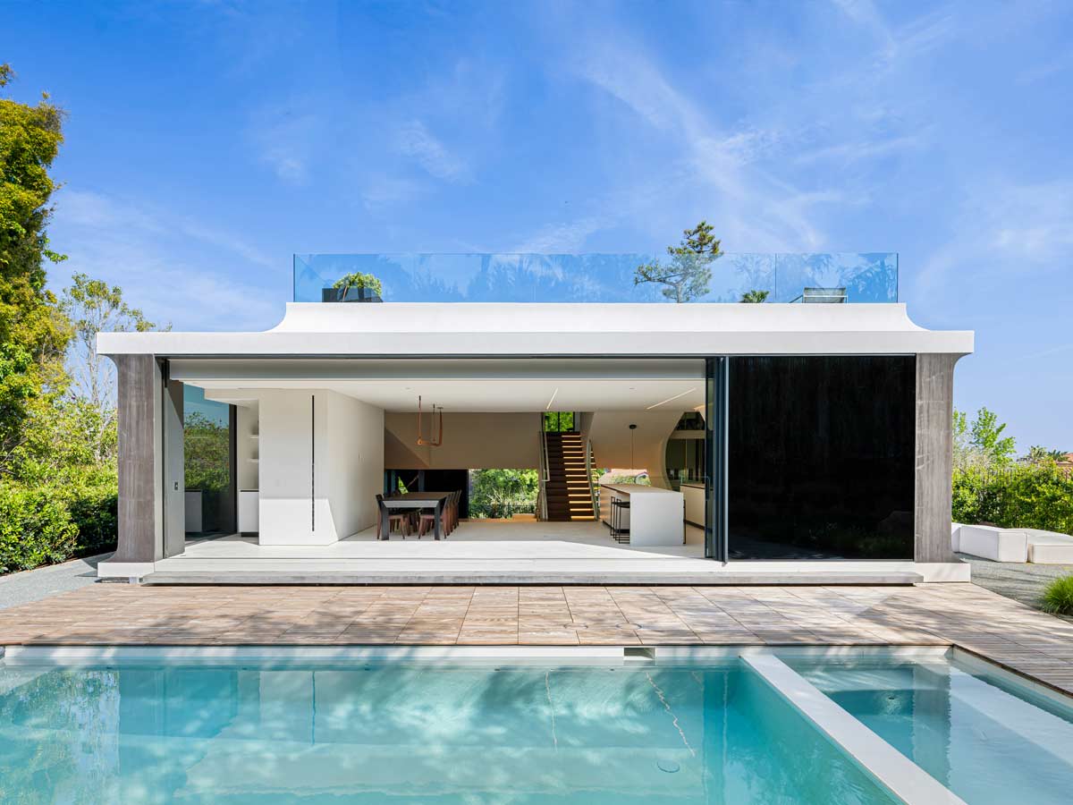 Exterior shot of a modern house with pool in front.