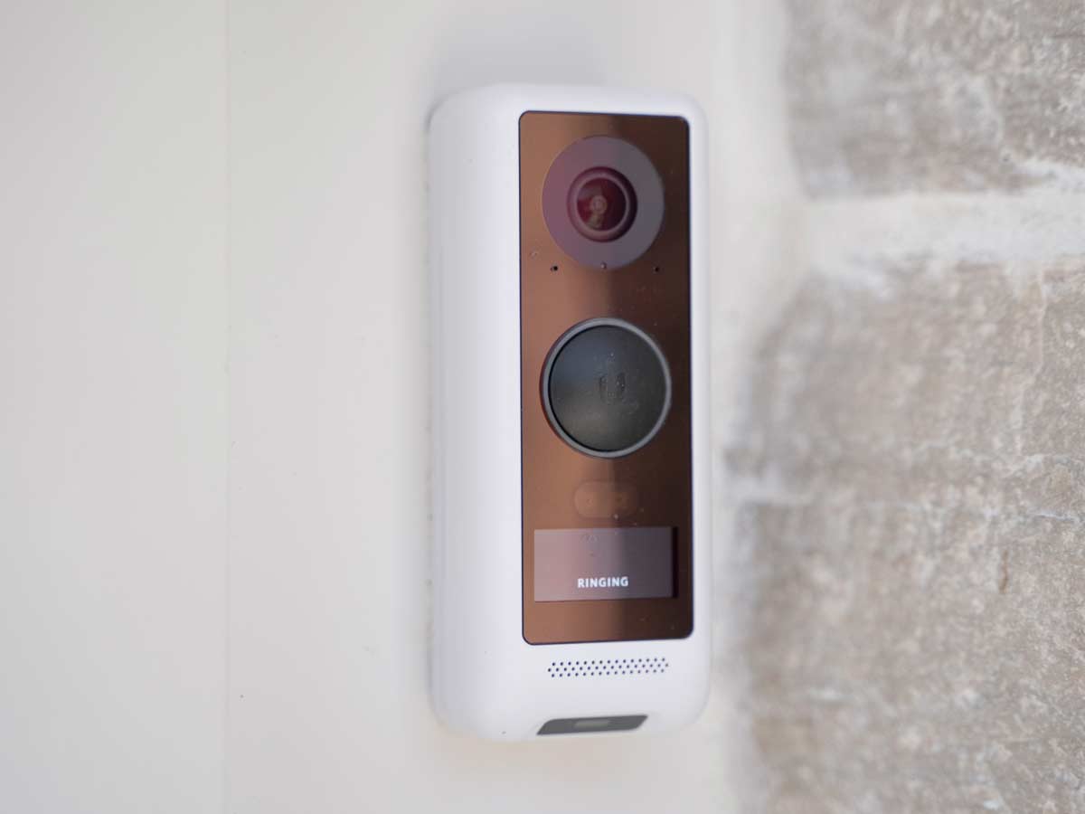Smart doorbell with camera mounted on wall.