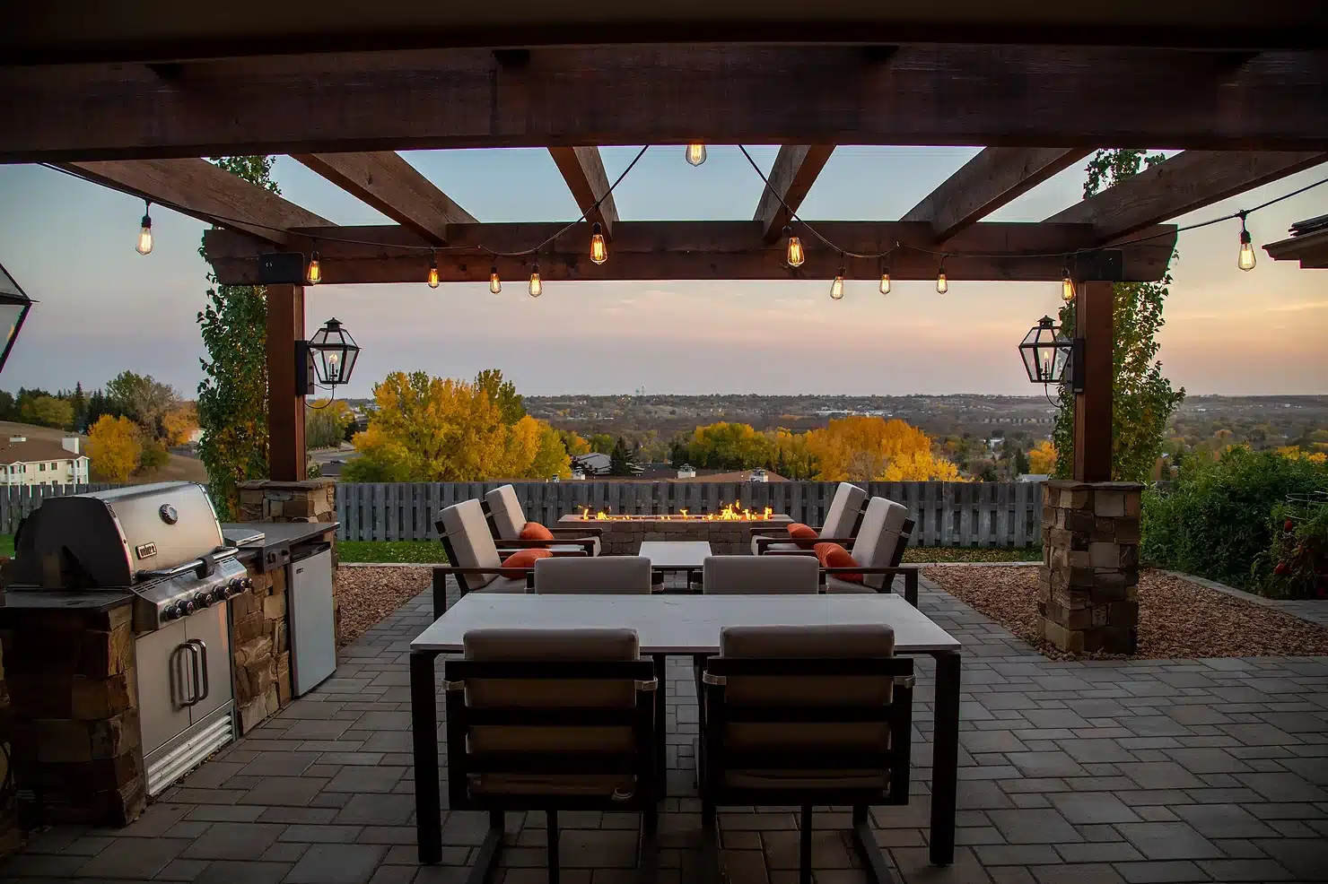 Patio with dining area and grill overlooking trees